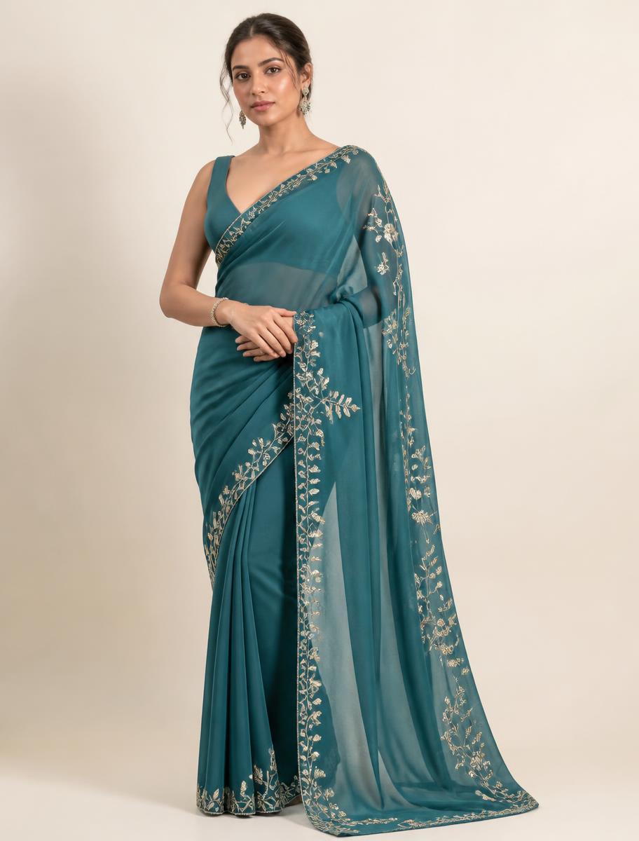 Woman wearing a teal designer saree with hand embroidered pallu