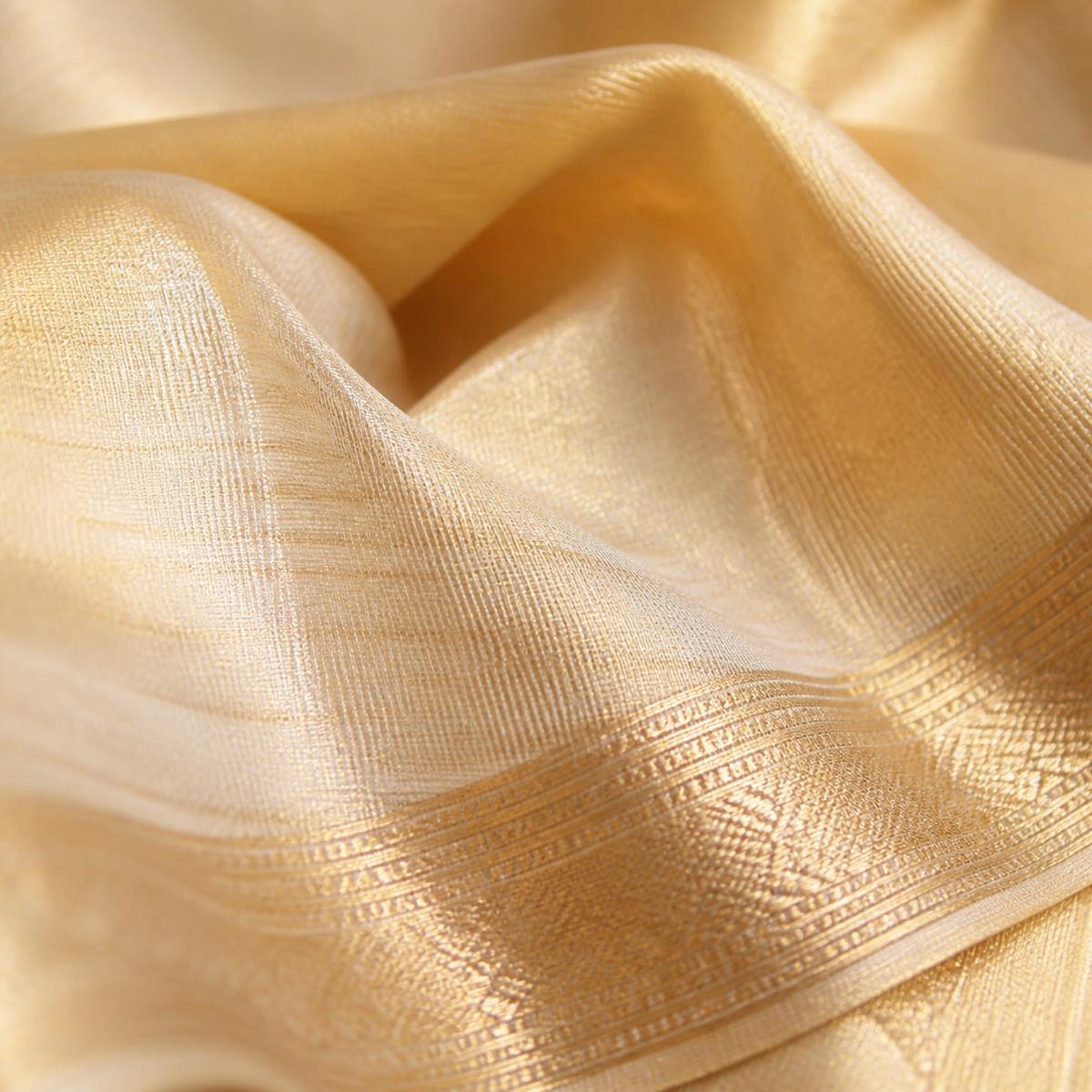 Close-up of gold tissue saree fabric with zari border detail